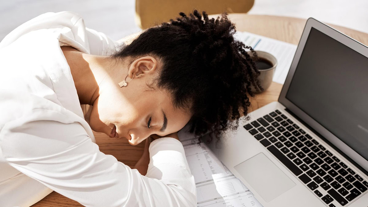 Person sleeping on her desk in office