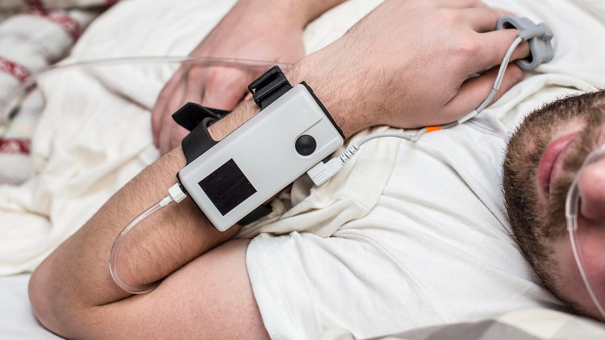 Person sleeping in his bed with home sleep apnea testing machine