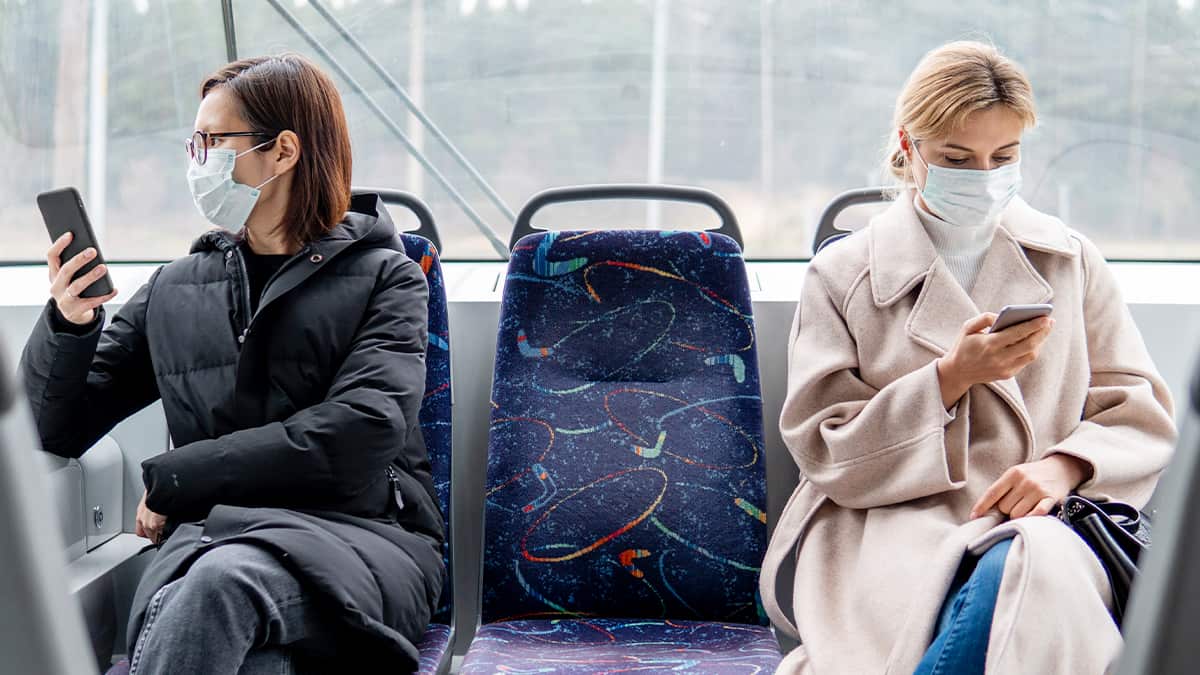 Women practicing social distance while in transit