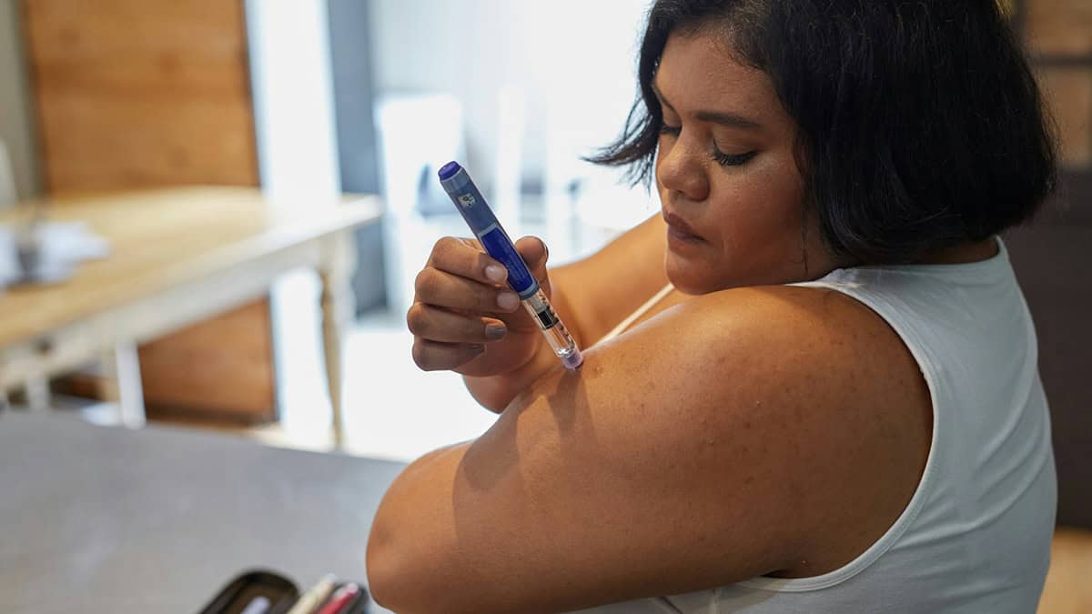 Person injecting insulin using insulin pen