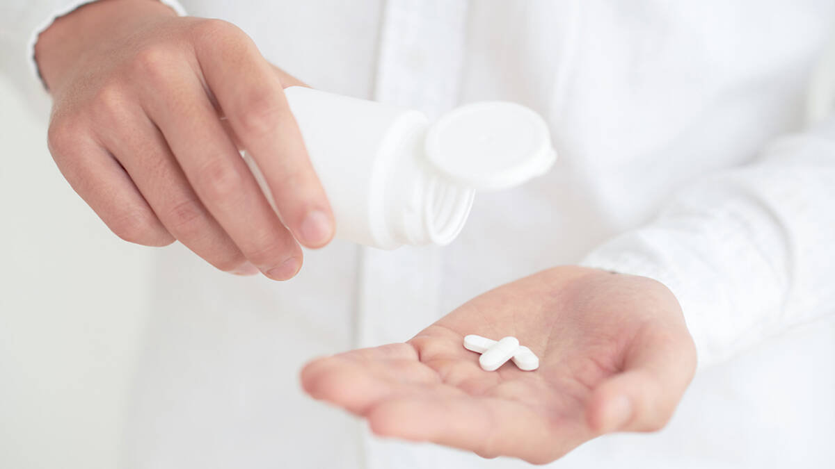 Person with medication dosage in hand