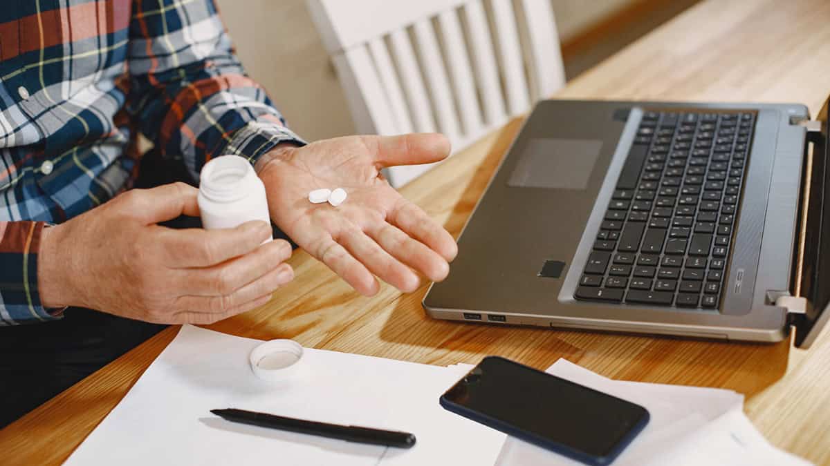 A person with medication and a laptop