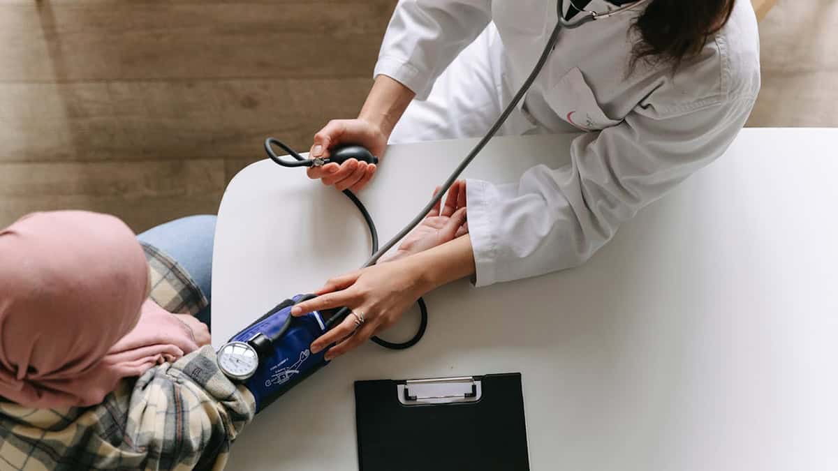 Doctor taking patient's blood pressure reading