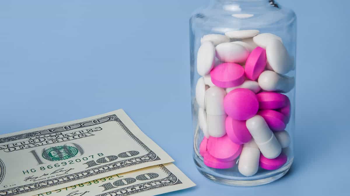 A bottle of supplements and 100 US dollar bills
