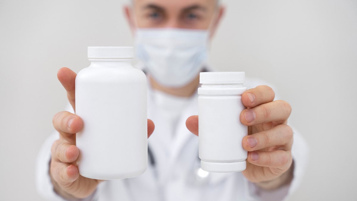 Pharmacist holding two types of medication bottles