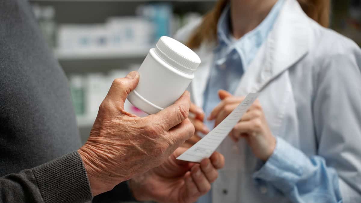 Person holding medication talking to a pharmacist