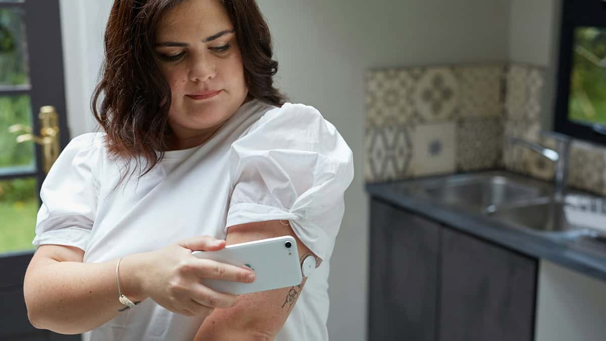Person setting up her blood sugar sensor