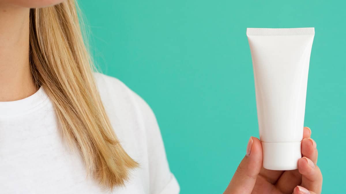 Person holding a tube of cream